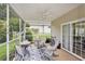 Comfortable screened-in patio features a ceiling fan, comfortable seating, and a view of the backyard at 203 Old Hickory Dr., Conway, SC 29526