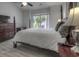 This bedroom features a ceiling fan, large window, 4-poster bed, and a light gray floor at 2180 Waterview Dr. # 738, North Myrtle Beach, SC 29582
