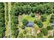 Aerial view of a home nestled among mature trees, featuring a vast, private lot at 265 Powell Loop, Andrews, SC 29510
