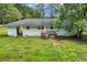 Exterior of a white brick home with a large, well-maintained backyard at 265 Powell Loop, Andrews, SC 29510