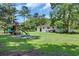 Spacious backyard with playset and surrounding mature trees, providing a scenic view at 265 Powell Loop, Andrews, SC 29510
