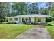 Charming single-story white brick home featuring a well-manicured lawn, driveway and cozy front porch at 265 Powell Loop, Andrews, SC 29510