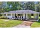 Charming single-story white brick home featuring a well-manicured lawn, driveway and cozy front porch at 265 Powell Loop, Andrews, SC 29510