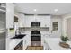 Bright kitchen features white cabinets, stainless steel appliances, and a black sink with wood-look flooring at 265 Powell Loop, Andrews, SC 29510