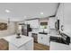 Open kitchen features white cabinets, an island, stainless steel appliances, and bright natural light at 265 Powell Loop, Andrews, SC 29510