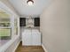 Bright laundry room with natural light, modern wallpaper, and overhead cabinets for ample storage at 265 Powell Loop, Andrews, SC 29510