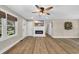 Cozy living room with fireplace, wall-mounted television, modern ceiling fan and hardwood floors at 265 Powell Loop, Andrews, SC 29510