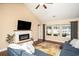 Cozy living room with a fireplace, hardwood floors, a ceiling fan, and ample natural light at 276 Avery Dr., Myrtle Beach, SC 29588