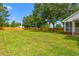 Expansive backyard featuring lush green grass, mature trees, and a wooden privacy fence at 2965 Mount Olive Rd., Loris, SC 29569