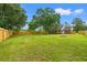 Large, fenced backyard with a brick house and mature trees providing shade at 2965 Mount Olive Rd., Loris, SC 29569