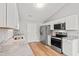 Bright kitchen with stainless steel appliances, granite countertops, white cabinets, and wood-look flooring at 2965 Mount Olive Rd., Loris, SC 29569