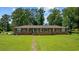 Charming brick home with black shutters, complemented by a lush green lawn and mature trees at 300 Crescent Dr., Conway, SC 29526