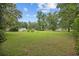 Large grassy front yard of a well-maintained home surrounded by mature trees under a partly cloudy sky at 300 Crescent Dr., Conway, SC 29526