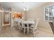 Bright dining area features a white table, six chairs, chandelier, and natural light, adjacent to the kitchen at 305 Hillside Dr. N # 205, North Myrtle Beach, SC 29582