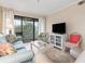 Inviting living room featuring a sofa, patterned armchairs, a TV, and access to the balcony at 305 Hillside Dr. N # 205, North Myrtle Beach, SC 29582