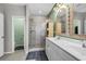 A bright bathroom with a glass-enclosed shower, double vanity, decorative mirrors, and tile flooring at 305 Splendor Circle, Murrells Inlet, SC 29576