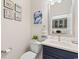 Powder room featuring a blue vanity with a white countertop and a decorative mirror on the wall at 3185 Viceroy Loop, Little River, SC 29566
