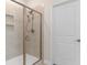 Modern tiled shower with glass door, rainfall shower head, and convenient built-in shelving at 3185 Viceroy Loop, Little River, SC 29566