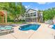 Backyard with pool, hot tub, and screened-in back of house on a sunny day at 3597 Sunfish St., Murrells Inlet, SC 29576