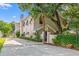 Stunning home featuring a stucco exterior, metal roof accents, gated entrance, and mature landscaping at 3597 Sunfish St., Murrells Inlet, SC 29576