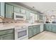 Charming kitchen with white appliances, light-blue cabinets, and decorative backsplash at 3597 Sunfish St., Murrells Inlet, SC 29576
