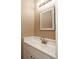 Well-lit powder room with white vanity, a chrome faucet, and a framed mirror at 3700 Golf Colony Lane # 25-D, Little River, SC 29566