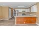 Open concept kitchen with stainless steel refrigerator, white cabinets, island, and wood-look floors at 3700 Golf Colony Lane # 25-D, Little River, SC 29566