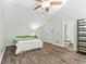 Bedroom features a ceiling fan, wood-look floors, and view into bathroom at 3700 Golf Colony Lane # 2-J, Little River, SC 29566