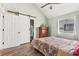 Bedroom with barn door closet, light-green walls, and wood-look floors for modern appeal at 3700 Golf Colony Lane # 2-J, Little River, SC 29566