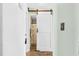 Hallway with white sliding barn door leading to bathroom at 3700 Golf Colony Lane # 2-J, Little River, SC 29566