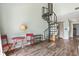 Living room features a spiral staircase, red bistro table, and wood-look floors at 3700 Golf Colony Lane # 2-J, Little River, SC 29566