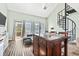 Bright living room with spiral staircase, modern sofa, and access to a balcony at 3700 Golf Colony Lane # 2-J, Little River, SC 29566