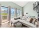 Bright living room with access to balcony, comfortable sofa, and spiral staircase at 3700 Golf Colony Lane # 2-J, Little River, SC 29566