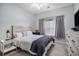 Bright bedroom with a large window, neutral gray tones, comfortable bed, and stylish furniture at 3951 Gladiola Ct. # 104, Myrtle Beach, SC 29588