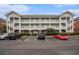 Three story condo building with multiple balconies and covered parking at 3951 Gladiola Ct. # 104, Myrtle Beach, SC 29588