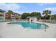 Community pool area with palm trees, lounge chairs, and building views at 3951 Gladiola Ct. # 104, Myrtle Beach, SC 29588