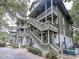 The exterior features multiple units with outdoor staircases, complemented by lush landscaping, creating a charming neighborhood feel at 404 72Nd Ave. N # 301, Myrtle Beach, SC 29572