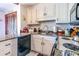 Compact kitchen featuring white cabinetry, granite countertops, and stainless steel appliances, designed for convenience and functionality at 404 72Nd Ave. N # 301, Myrtle Beach, SC 29572
