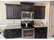 Well-equipped kitchen with granite countertops, stainless steel appliances, and dark wooden cabinetry at 429 Oakham Dr., Conway, SC 29526