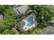 Aerial view of a community pool featuring lounge chairs, a hot tub, and mature landscaping at 4450 Little River Inn Ln. # 601, Little River, SC 29566