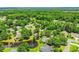 Aerial view of a residential neighborhood with mature trees, a pond, and well-maintained homes at 4499 Firethorne Dr., Murrells Inlet, SC 29576