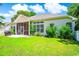 Home exterior showcasing a well-manicured backyard, screened porch, and lush landscaping at 4499 Firethorne Dr., Murrells Inlet, SC 29576