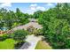 Aerial view of a brick home with mature landscaping, a long driveway, and a swimming pool in the distance at 4499 Firethorne Dr., Murrells Inlet, SC 29576