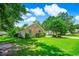 Side view of a brick house with a well-kept lawn, complemented by mature trees and thoughtful landscaping at 4499 Firethorne Dr., Murrells Inlet, SC 29576