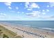 High-angle shot of a beach with many sunbathers, umbrellas, and a beautiful ocean view at 4800 S Ocean Blvd. # 1524, North Myrtle Beach, SC 29582