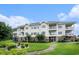 View of an apartment complex with multiple balconies and manicured landscaping at 4868 Dahlia Ct. # 202, Myrtle Beach, SC 29577