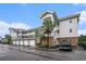 Exterior view of condo complex with attached garages and palm trees on a cloudy day at 4868 Dahlia Ct. # 202, Myrtle Beach, SC 29577