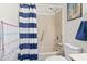 Bathroom featuring a shower-tub combo, blue striped curtain, shower head, and single sink vanity at 500 Fairway Village Dr. # J-7, Myrtle Beach, SC 29588
