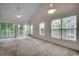 Spacious living room with large windows, sliding glass doors, vaulted ceilings and ceiling fan at 5046 Belleglen Court # 202, Myrtle Beach, SC 29579