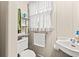 This bathroom features a sink, toilet, shelving, and a window with natural light at 506 28Th Ave. N, Myrtle Beach, SC 29577